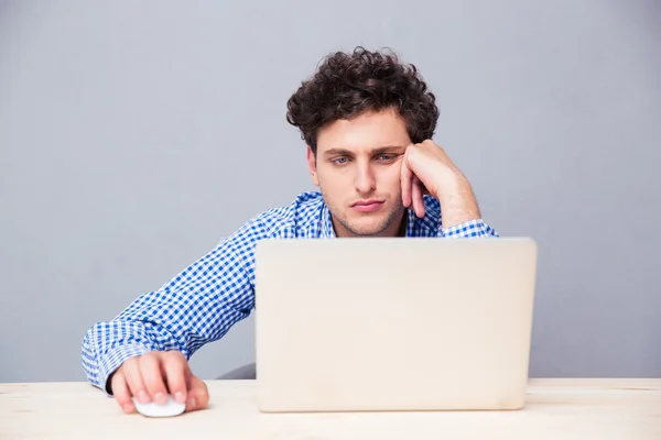 Hombre joven casual usando el ordenador portátil — Foto de Stock