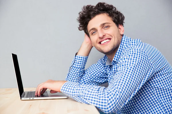 Glimlachend busienssman zitten aan de tafel met laptop — Stockfoto