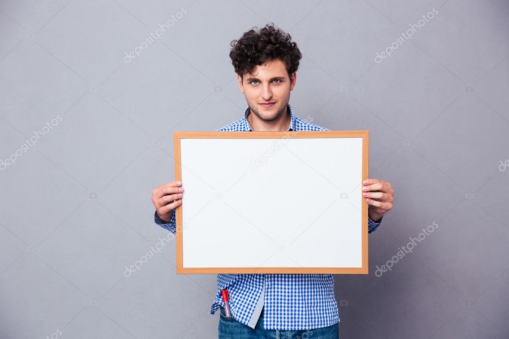 Casual young man holding blank board 