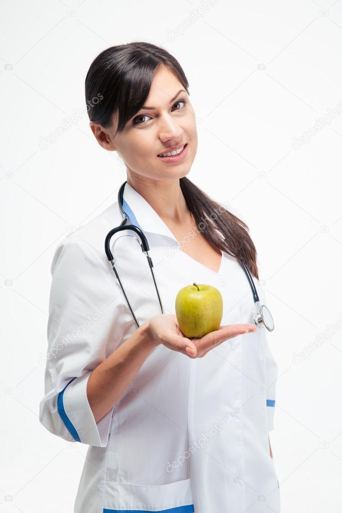Smiling female doctor holding apple 