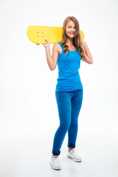 Leende flicka håller skateboard — Stockfoto