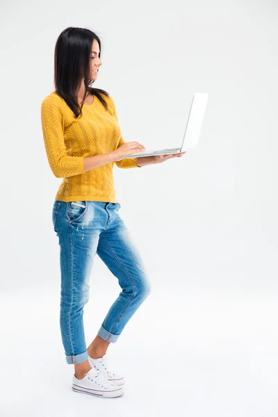 Mujer joven de pie y el uso de ordenador portátil — Foto de Stock