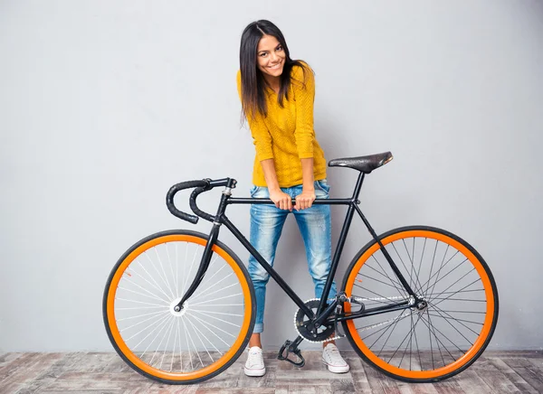 Smiling woman standing near bicycle