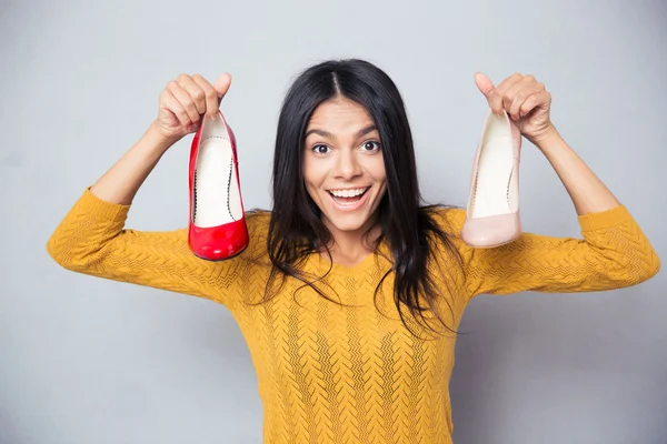 Joven alegre sosteniendo zapatos — Foto de Stock