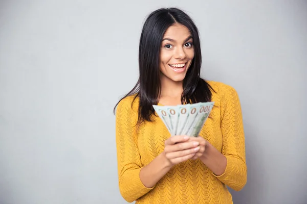 Cheerful woman holding dollar bills — Stock Photo, Image