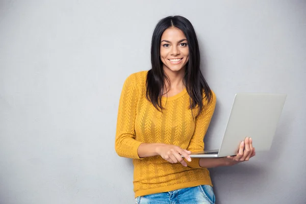 Glad ung kvinna anläggning laptop — Stockfoto