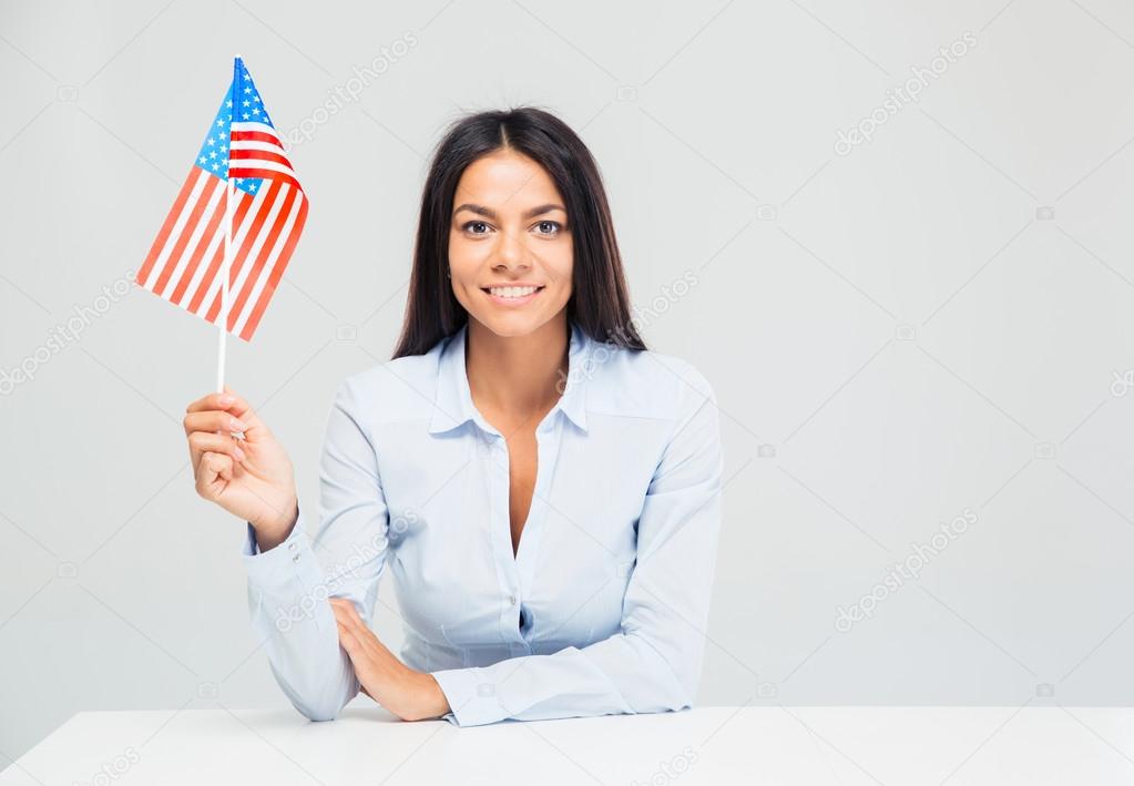 Businesswoman sitting at the table with american flag