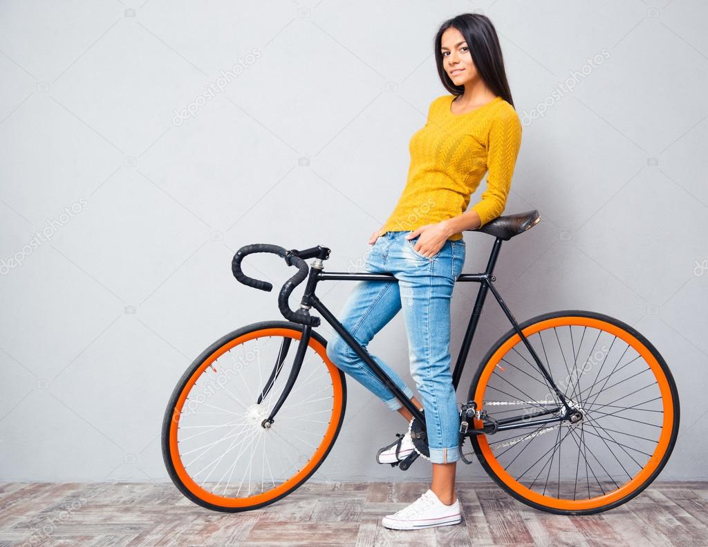 Happy casual woman standing with bicycle