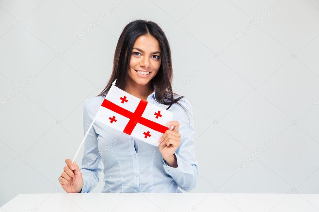 Woman sitting at the table with georgian flag