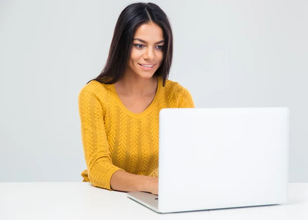 Frau sitzt am Tisch und benutzt Laptop — Stockfoto