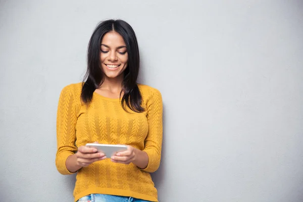 Leende kvinna som använder smartphone — Stockfoto