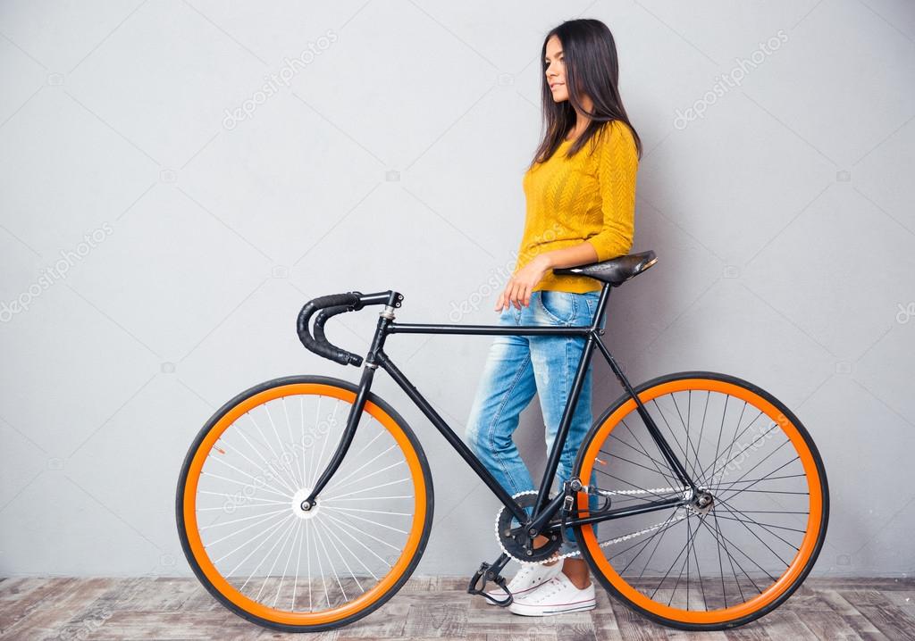 Smiling woman standing near bicycle