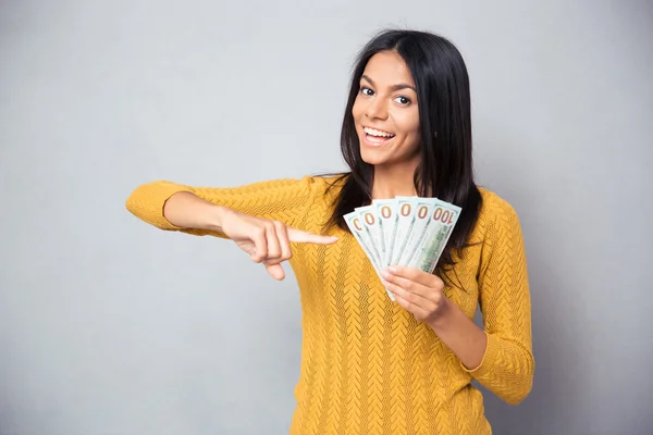Femme pointant du doigt sur des billets de dollar — Photo