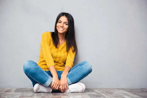 Sorridente donna casual seduto sul pavimento — Foto Stock