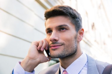 Mutlu iş adamı telefonda konuşuyor.