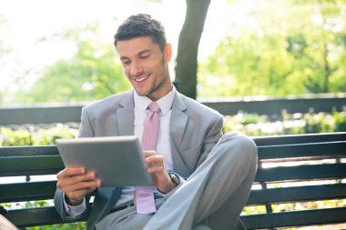 Tablet bilgisayar açık havada kullanarak iş adamı