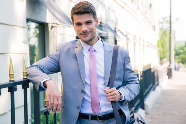 Açık havada kameraya bakarak mutlu işadamı