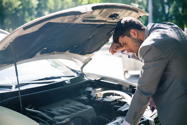 Hombre mirando bajo el capó del coche — Foto de Stock