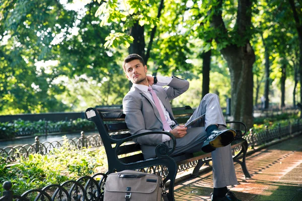 Affärsman som sitter på bänken med tablet PC — Stockfoto