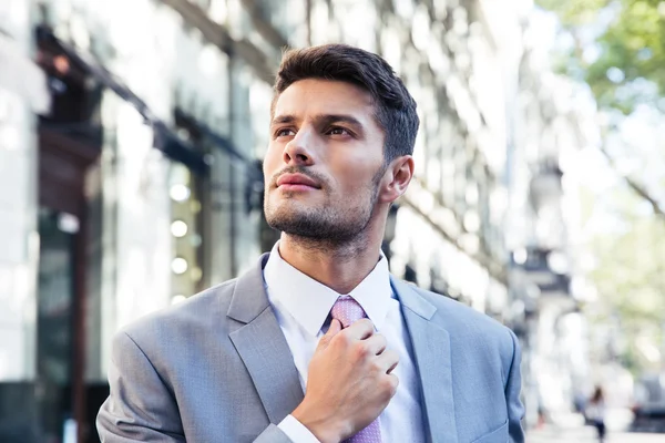 Empresário endireita sua gravata — Fotografia de Stock