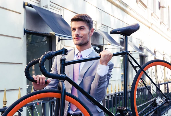 Businessman carrying his bicycle — Stock Photo, Image