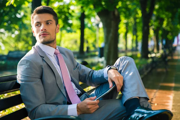 Businessman sitting on the bench with tablet computer — Stock Photo, Image