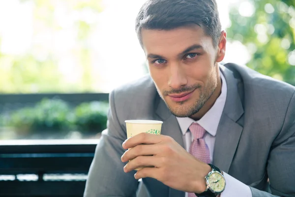 Businessman drinking coffee outdoors — Stock Photo, Image