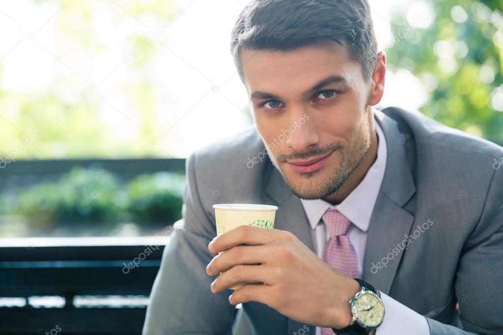 Businessman drinking coffee outdoors