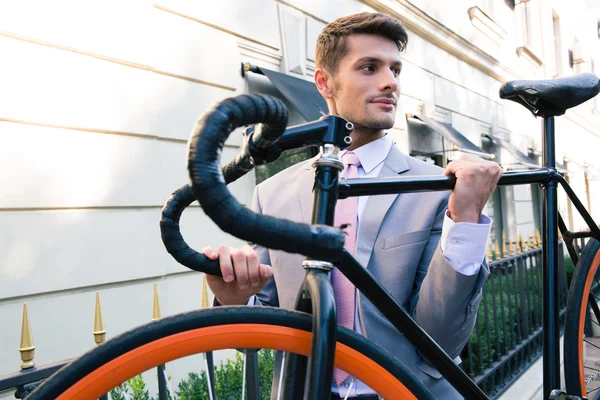 Empresário carregando sua bicicleta — Fotografia de Stock