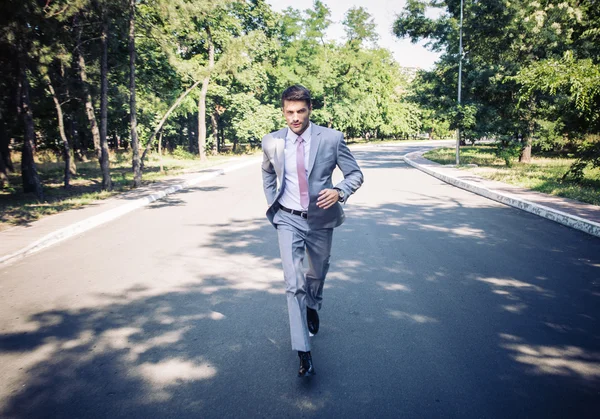 Businessman running in park — Stock Photo, Image