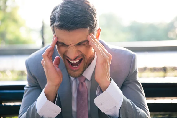 Empresario con dolor de cabeza al aire libre — Foto de Stock