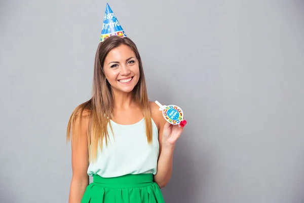 Happy young girl in birthday hat and whistle