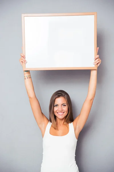 Sorrindo jovem segurando placa em branco — Fotografia de Stock