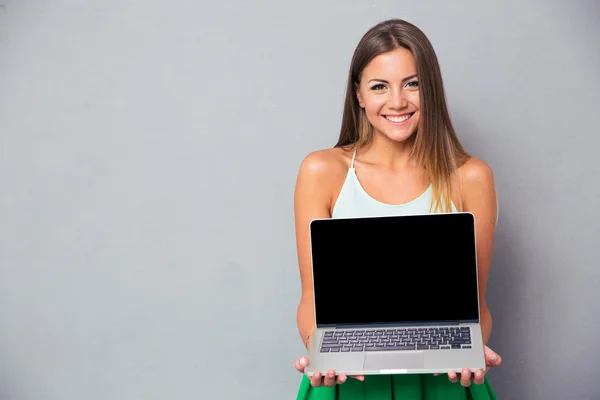 Kvinde viser tom laptop computerskærm - Stock-foto