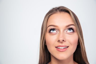 Gülümseyen genç kadın yukarı bakıyor.