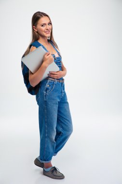 Dizüstü tutarak ve kameraya bakarak kız öğrenci