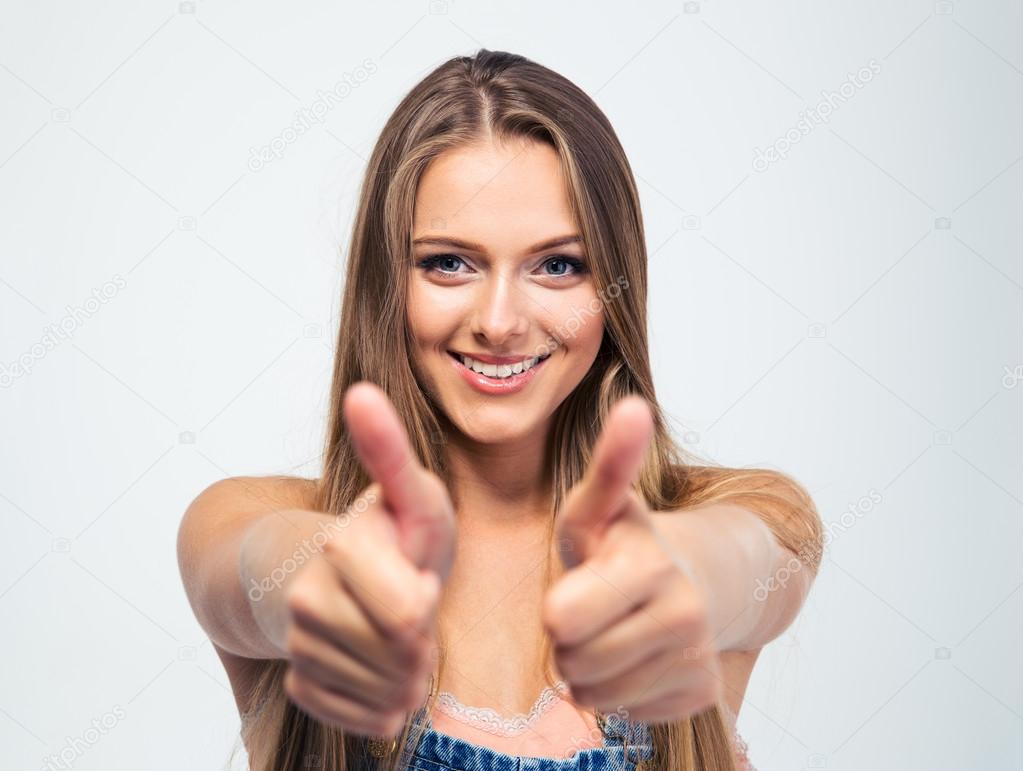 Smiling young girl showing thumbs up