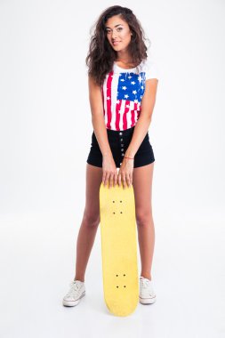 Tam uzunlukta kaykay tutan bir genç kız portresi