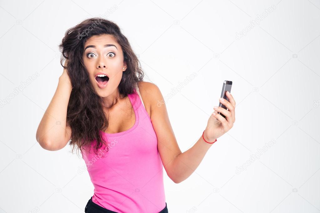 Shocked woman standing with smartphone 