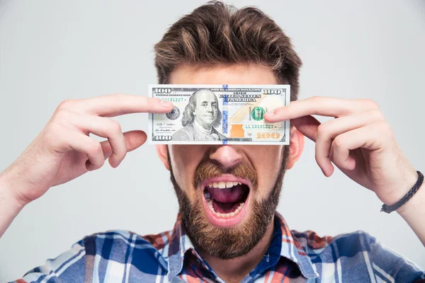 Manbeläggning hans ögon med räkning av Usa dollar — Stockfoto