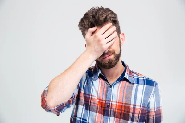 Portret van boos man die betrekking hebben op zijn gezicht met hand — Stockfoto