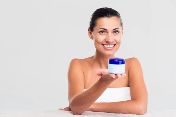 Woman in towel sitting at the table and holding cream jar — Stock Fotó