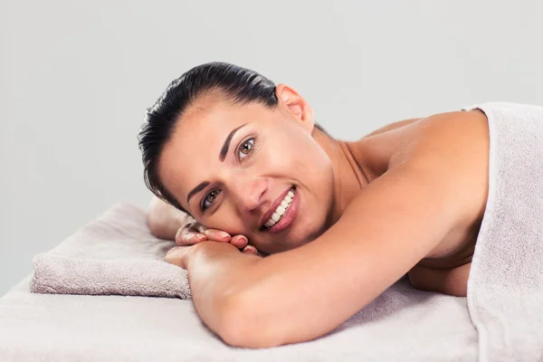 Happy cute woman lying on massage lounger — Stock Photo, Image