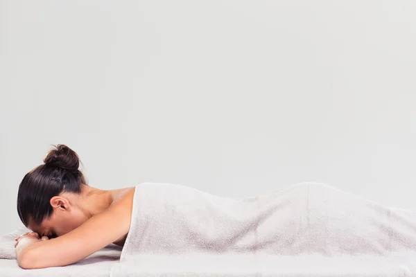 Woman lying on massage lounger — Stock Photo, Image