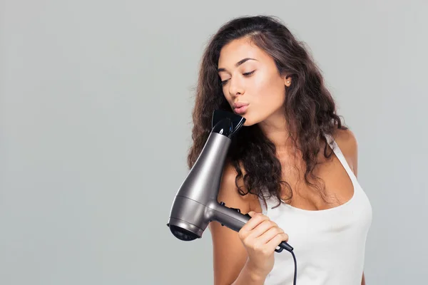 Pretty woman blowing on hairdryer — Stock Photo, Image