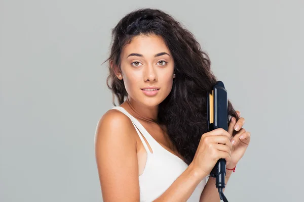 Vrouw doen kapsel met hair straightener — Stockfoto