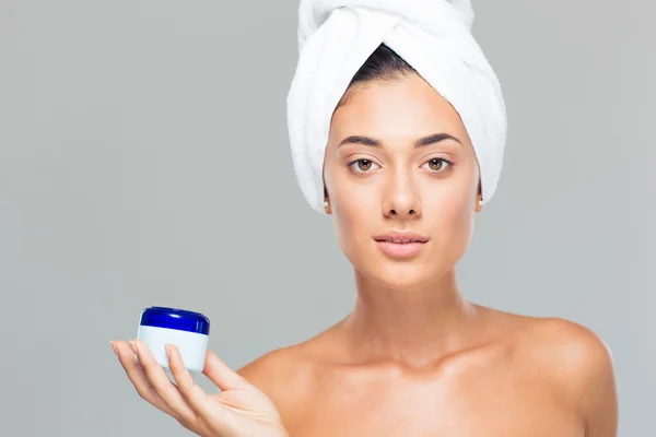 Woman with towel on head holding cream jar — Stock Photo, Image