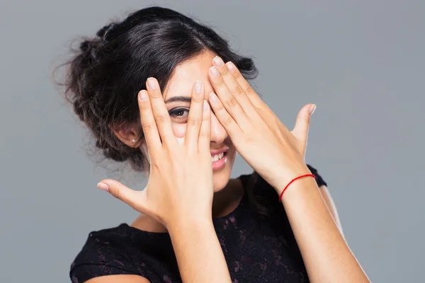 Mulher feliz cobrindo seu olho com o dedo — Fotografia de Stock