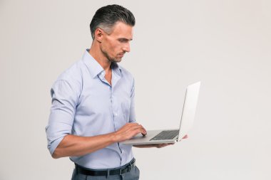 Dizüstü bilgisayar kullanan yakışıklı bir adam portresi 