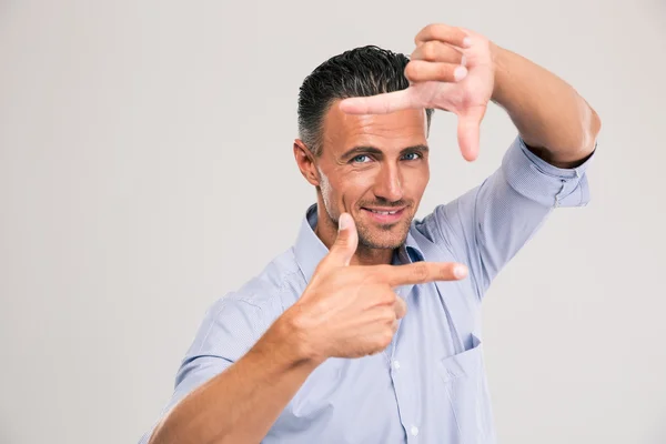 Empresário sorridente fazendo moldura com os dedos — Fotografia de Stock